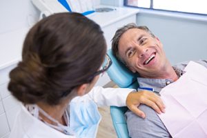 dentist checking on the man's smile for the dental emergency