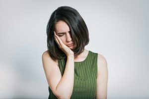 person experiencing a dental emergency; dealing with jaw pain (TMJ)